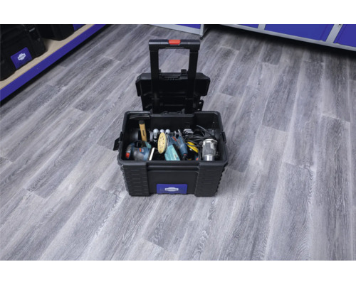 Open gereedschapskist met gereedschap en telescopische handgreep op een houten vloer