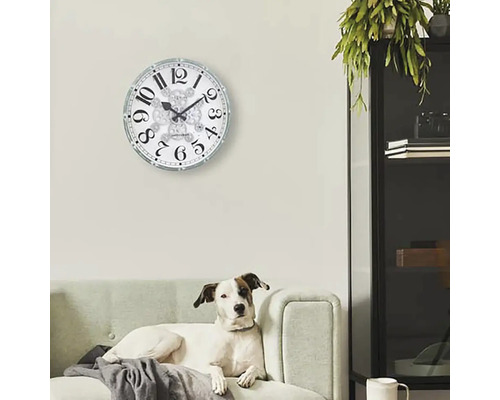 Woonkamer met wandklok en hond op de bank