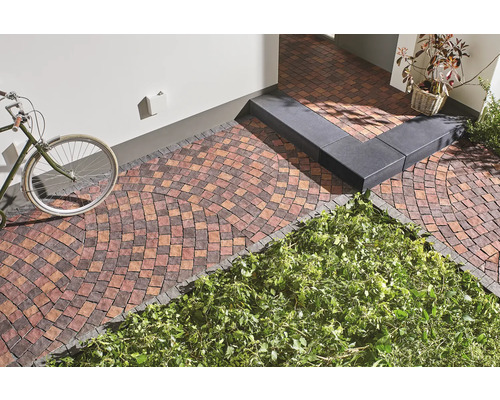 Bestrate buitenruimte met fiets, trap en beplanting