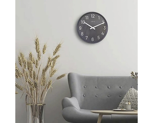 Woonkamer met grijze bank, tafel, decoratie en ronde wandklok