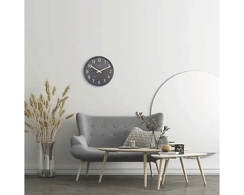 Woonkamer met grijze bank, salontafels, wandklok en decoratie