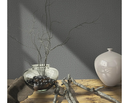 Decoratieve scène met vaas, takken en textieldoek op houten tafel voor een grijze wand