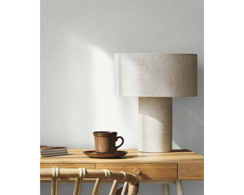 Decoratieve kamer met tafellamp, kop, notitieboekjes en rotan stoel
