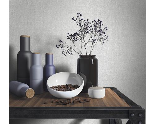 Decoratieve opstelling met flessen, schaal, plant en blik op een plank