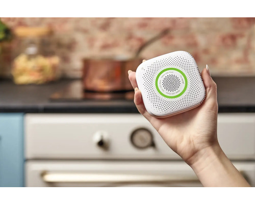 Hand houdt rookmelder vast voor keukengebruik