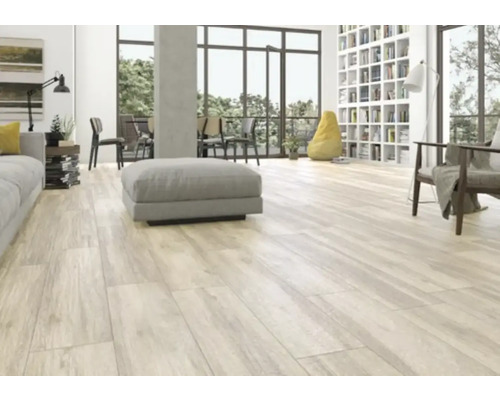 Lichte woonkamer met houten vloer in plankmotief, bank, fauteuil en boekenkast