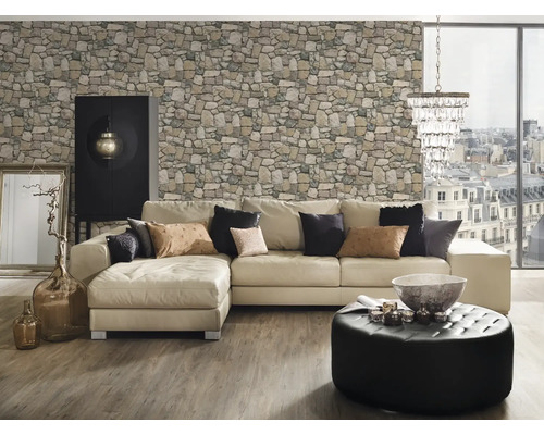 Woonkamer met hoekbank, stenen behang, ottomane, kast en decoraties.