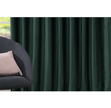 Decoratief, groen gordijn naast een fauteuil met kussen.