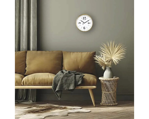 Woonkamer met bank, houten tafel, wandklok en decoraties.