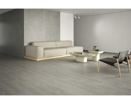 Lichte woonkamer met bank, tafels, stoelen en vloertegels in houtlook