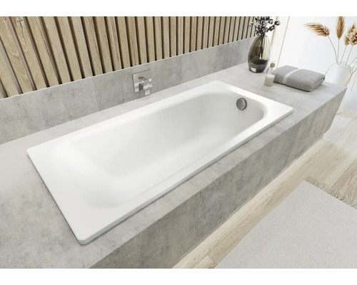 Witte badkuip ingebouwd in een badkamer met tegelrand.