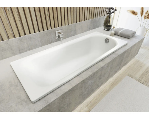 Ingebouwde badkuip in de badkamer met kraan en badkameraccessoires op de badrand