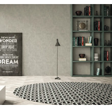Woonkamer met rond vloerkleed, vloerlamp, rek en decoratieve print