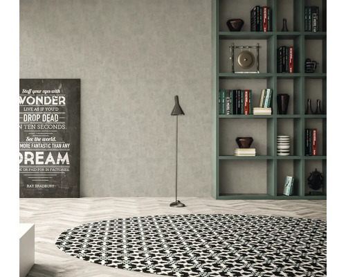 Woonkamer met rond vloerkleed, vloerlamp, rek en decoratieve print