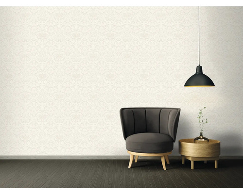 Woonkamer met patroonbehang, fauteuil, bijzettafel en hanglamp