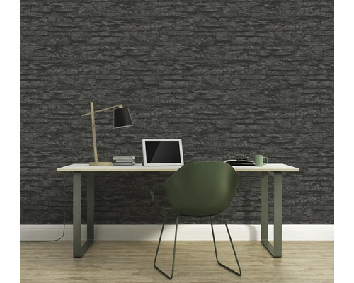 Kantoor met stenen behang, bureau, lamp, laptop en stoel