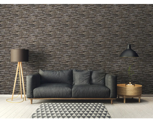 Woonkamer met grijze bank, vloerlamp en steenstripsbehang