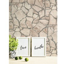 Muur met steenmotief en twee fotolijsten met de opschriften liefde en ademen.