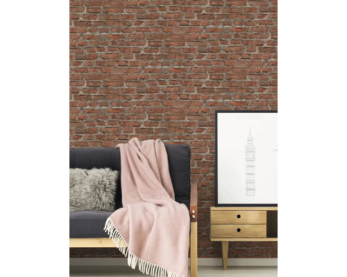 Woonkamer met bakstenen muur, bank, kussen, deken, bijzettafel en poster van Londen