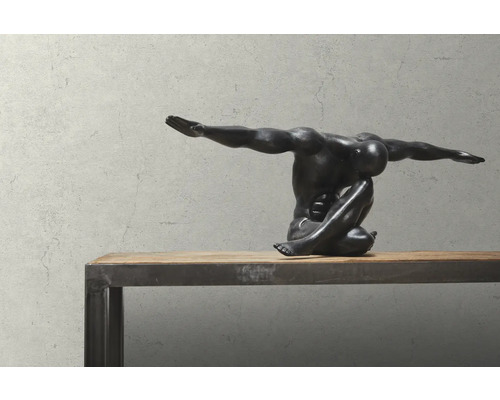 Decoratief beeld van een zittende, gespierde figuur op een houten tafel