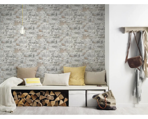 Woonkamer met behang met baksteenmotief, zitbank met kussens, houtblokken en decoratie