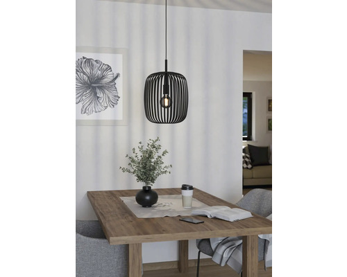 Eetkamerscène met houten tafel, stoelen en zwarte hanglamp