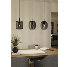 Drie metalen hanglampen boven een eettafel.