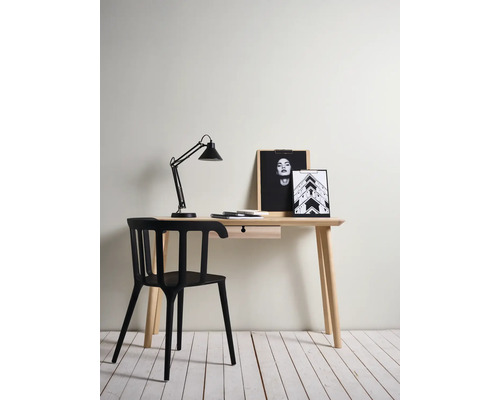 Een bureau met lade, lamp, foto''s en een zwarte stoel.