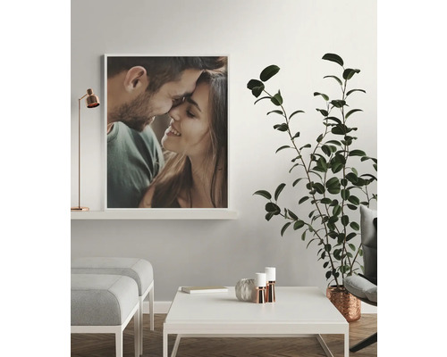 Woonkamer met ingelijst portret van een paar, kamerplant, salontafel en krukken