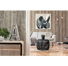 Woonkamer met houten wandbekleding, bank en decoratieve elementen zoals een tafel, lamp en schilderij