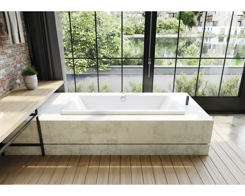 Vrijstaand bad in een lichte badkamer met uitzicht op een meer