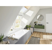 Lichte badkamer met dakramen, ligbad, wastafel en spiegel in een modern huis.
