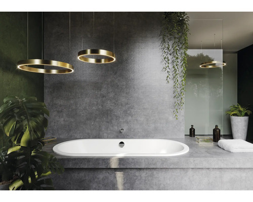 Badkamer met ligbad, planten en cirkelvormige lampen