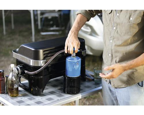 Persoon sluit gasfles aan op gasbarbecue