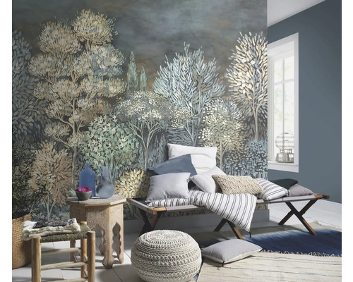 Woonkamer met een wandbehang met een bosmotief, een bank met kussens, een kruk en een vloerkleed.