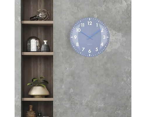 Een blauwe wandklok met een wijzerplaat hangt aan een grijze muur naast een houten plank.