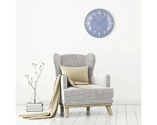 Woonkamer met fauteuil en blauwe wandklok