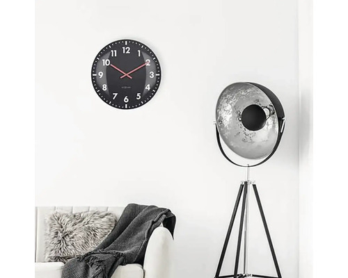 Woonkamer met wandklok, vloerlamp en bank