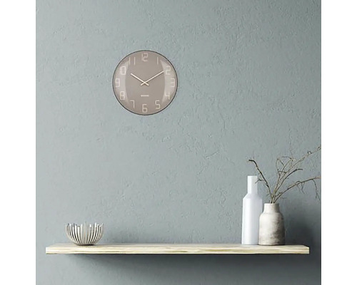 Wandklok met wijzerplaat op een plank met decoratieve objecten