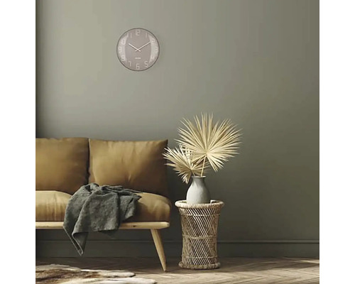 Woonkamer met bank, bijzettafel, decoratie en ronde wandklok