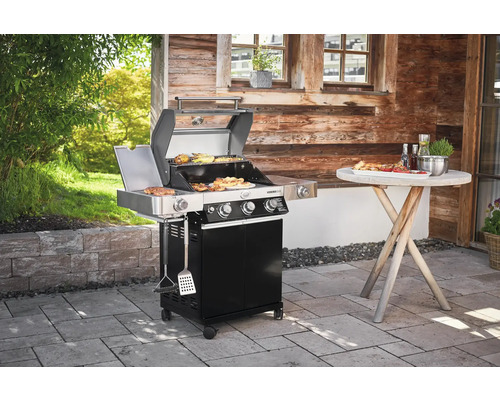 Gasbarbecue met gegrild eten en een houten tafel buitenshuis