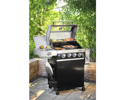 Gasbarbecue met voedsel op het grillrooster in de tuin