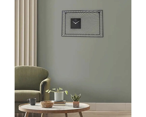 Woonkamer met fauteuil, tafel en rechthoekige wandklok