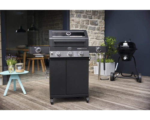 Zwarte gasbarbecue naast kogelbarbecue buiten