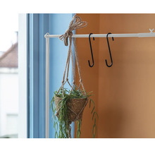 Hangende plantenbak met plant aan wit kledingrek