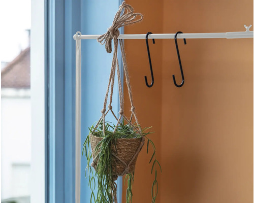 Hangende plantenbak met plant aan wit kledingrek