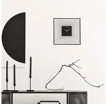 Decoratief interieur met een vierkante wandklok, kaarsen en een vaas met tak