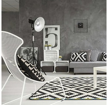 Moderne woonkamer met bank, fauteuil, tapijt en decoratie in grijstinten