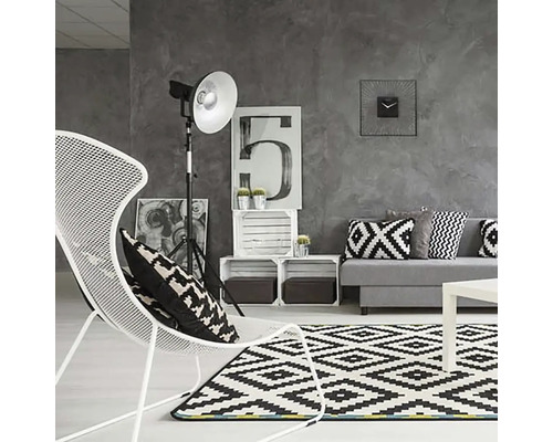 Moderne woonkamer met bank, fauteuil, tapijt en decoratie in grijstinten