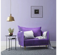 Woonkamer met fauteuil, bijzettafel, hanglamp en wandklok